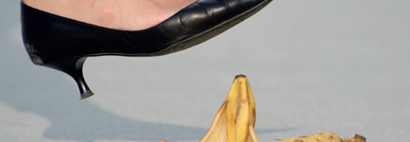 Kitten heeled, pointed shoe about to step on a banana skin