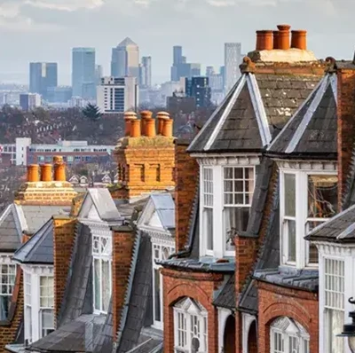 Edwardian terraced housing descending down a hill with London's Canary Wharf's office tower blocks in the distance