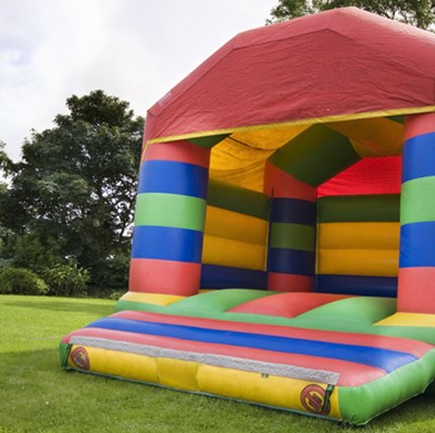 A bouncy castle in a football pitch, with a backdrop of trees A bouncy castle in a football pitch, with a backdrop of trees