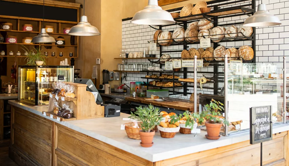 Bakery counter and till with loaves of bread in the background