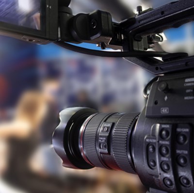 Side view of a video camera with blurred studio background