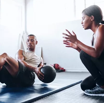 Personal Trainer Coaching Client Through A Workout Regime2 Personal Trainer Coaching Client Through A Workout Regime2