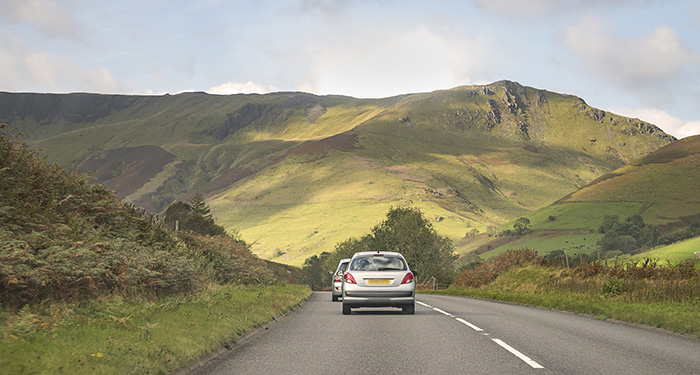 Cars Driving Towards Green Mountains Of Eryri Snowdonia