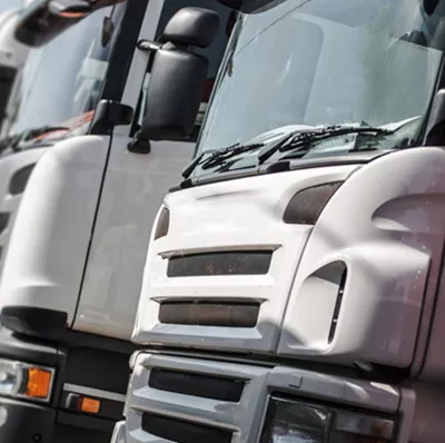 Front view of a row of parked white trucks