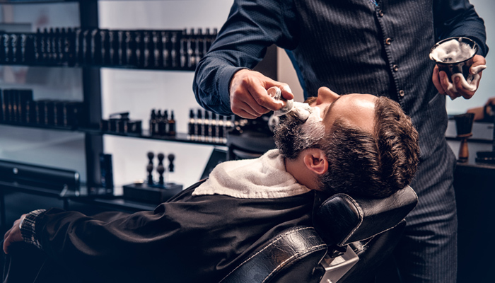 Barbers With Customer Having Beard Trimmed