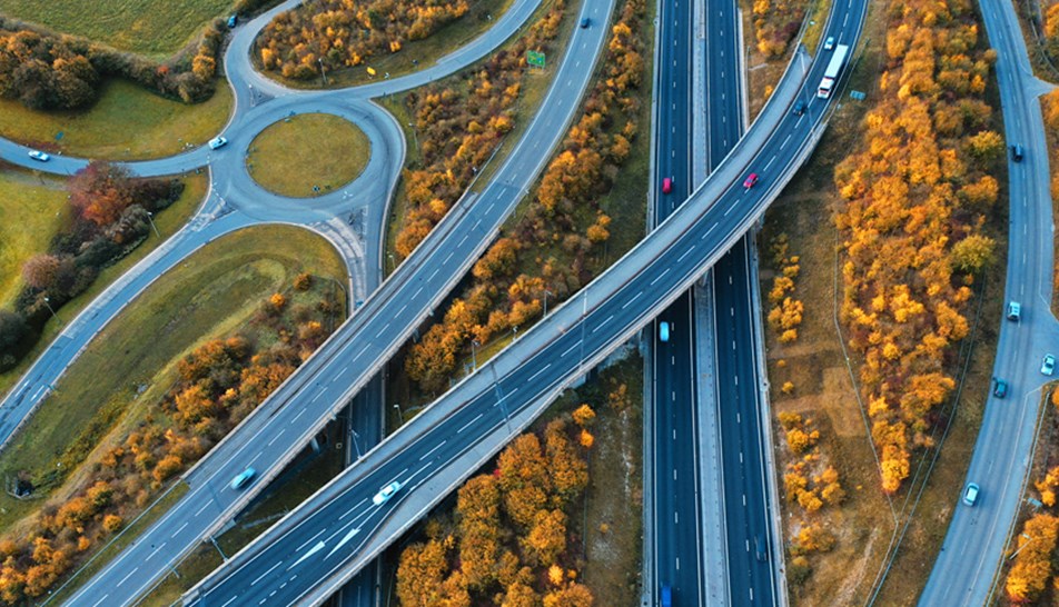 Aerial view of motorway with autumn trees between roads