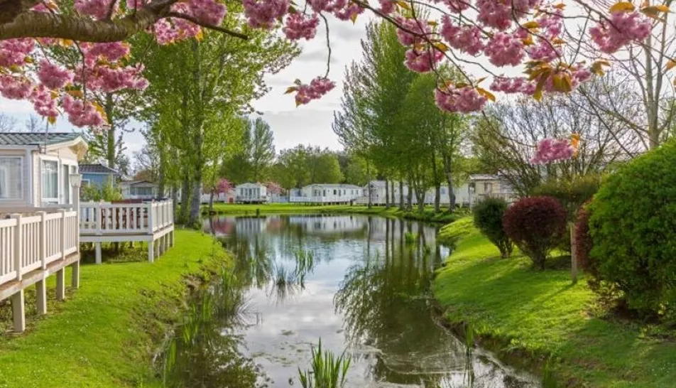 Static homes in rows along both sides of a beautiful greenery water feature