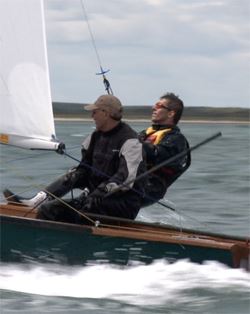 two men learning to sail in a dinghy