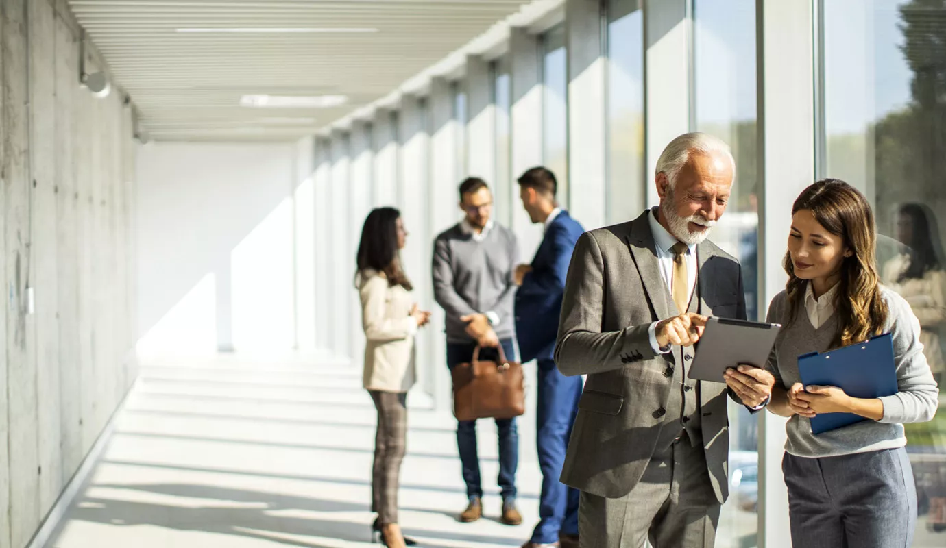 Group of business people standing in an office hallway and in discussion