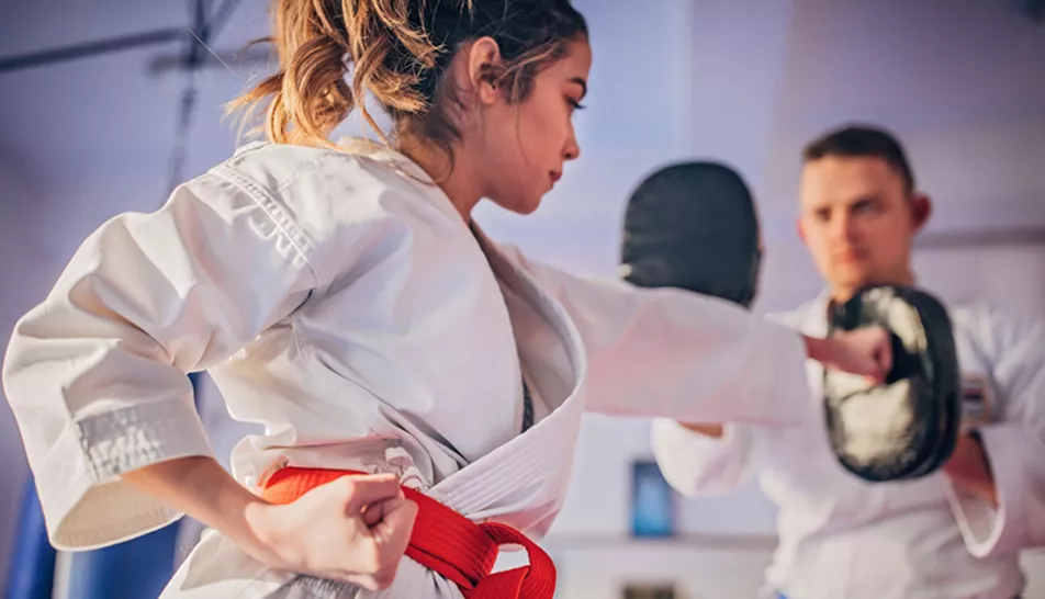 Woman practicing martial arts with a male peer