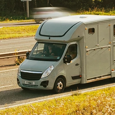 Horse box being driven on a motorway with grass verges Horse box being driven on a motorway with grass verges