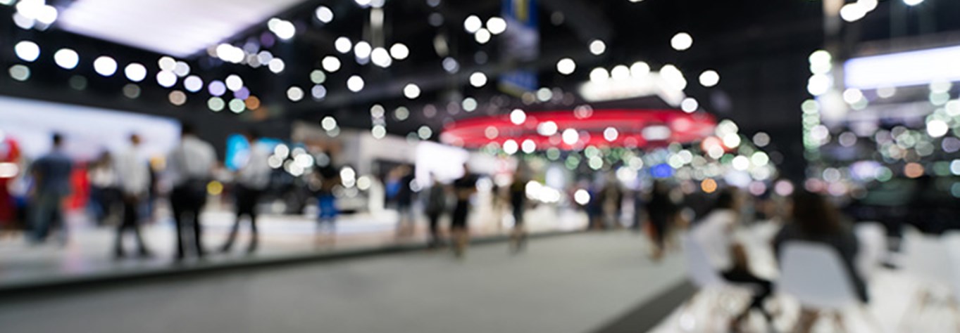 Blurred image of people at a stalls at an exhibition centre